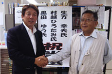 黒田さんと固く握手し、当選を確認し合う、千葉地本・石井副委員長